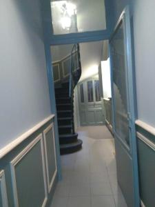 a hallway with a blue door and a staircase at Appartement Hippolyte in Montpellier