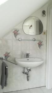 a white bathroom with a sink and a mirror at Haus Nautilus in Helgoland