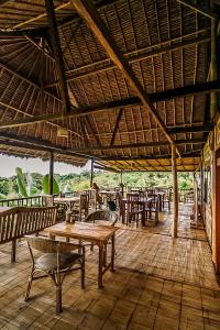 a restaurant with tables and chairs on a wooden floor at Echo Alam Nusa Lodge in Nusa Penida