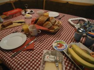 een tafel met borden en een mand met brood en bananen bij Medemblik Bed and breakfast in Medemblik