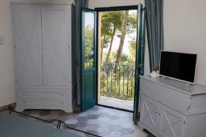 a room with a bed and a television at Hotel Villa Delle Meraviglie in Maratea