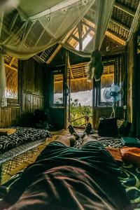 une personne dormant sur un lit dans une pièce dans l'établissement Echo Alam Nusa Lodge, à Nusa Penida