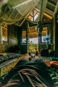 ペニダ島にあるEcho Alam Nusa Lodgeの相部屋のベッドに横たわる者