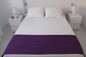 a white bed with a purple blanket on it at Luxury Duplex Las Palmeras in Los Alcázares
