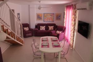 - un salon avec une table et un canapé dans l'établissement Luxury Duplex Las Palmeras, à Los Alcázares