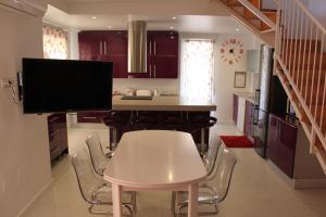 a kitchen with a white table and a tv at Luxury Duplex Las Palmeras in Los Alcázares