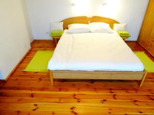 グディニャにあるApartment Amber 127m2 + terraceのウッドフロアのベッドルーム1室(白いシーツ付きのベッド1台付)