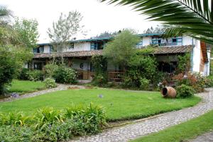 a house with a garden in front of it at Las Palmeras Inn in Otavalo