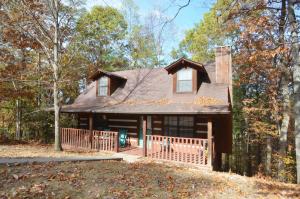 a house with a porch in the woods at Emerald Woods in Pigeon Forge