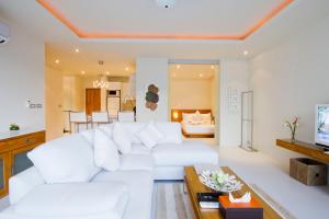 a white living room with a white couch at Chi Samui Resort in Bophut