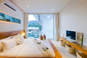 a bedroom with a large bed and a large window at Chi Samui Resort in Bophut