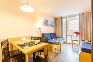 a living room with a dining room table and a couch at SOWELL RESIDENCES Le Port in Trouville-sur-Mer