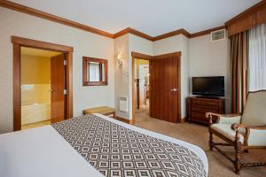 um quarto de hotel com uma cama e uma televisão em Crowne Plaza Lake Placid, an IHG Hotel em Lake Placid