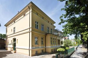 ein gelbes und weißes Gebäude auf einer Straße in der Unterkunft Guest house Villa Fritz in Potsdam