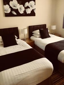 um quarto de hotel com duas camas com lençóis pretos e brancos em Alder Lodge em Cambridge
