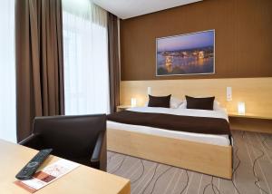 a hotel room with a bed and a desk at Promenade City Hotel in Budapest