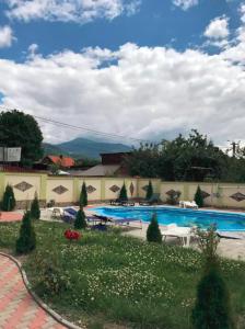 uma grande piscina num quintal com um edifício em Vila Maria em Petrila