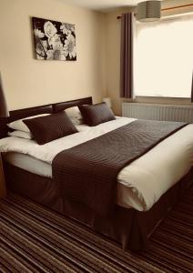 ein großes Bett in einem Schlafzimmer mit Fenster in der Unterkunft Alder Lodge in Cambridge