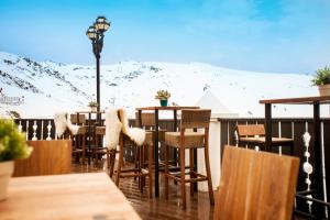 a table and chairs on a balcony with a snow covered mountain at Vincci Selección Rumaykiyya in Sierra Nevada