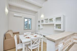 a kitchen and living room with a table and chairs at Appartamento Costa del Sole in Pomonte