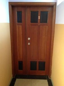 uma porta de madeira num quarto com uma parede em Bastos'Appart YAOUNDE em Iaundé