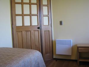 a bedroom with a door and a bed next to a table at Portal Austral in Puerto Montt