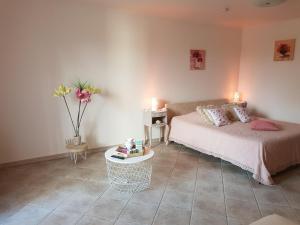 a bedroom with a bed and a table and flowers at A l'Orée du Pin in Puyricard