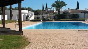- une piscine en face d'une maison dans l'établissement V2 Aldeia Do Golf- Piscina, Familiar, Aconchegante, à Vilamoura
