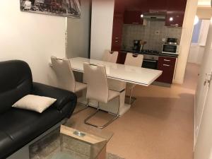 Una sala de estar con una mesa blanca y un sofá. en Appartement Rue Victor Hugo - Port de la Houle, en Cancale