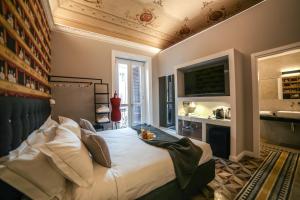 パレルモにあるFamily Affair Luxury Rooms&Suitesのベッドルーム(大型ベッド1台付)、バスルームが備わります。