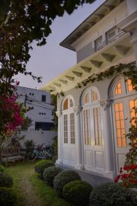 une maison blanche avec des fenêtres et des buissons dans l'établissement Villa Barranco by Ananay Hotels, à Lima