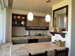 a kitchen with a counter and a sink and a mirror at The Monarca in Ixtapa