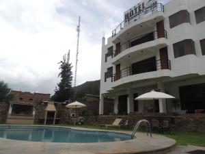 a hotel with a swimming pool in front of a building at Samay Wasi Hotel Chalhuanca in Chalhuanca