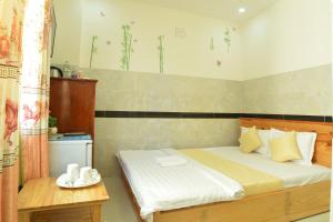 - une chambre avec un lit et une table dans l'établissement Hoang Chau Motel, à Vung Tau
