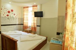 - une chambre avec 2 lits et une télévision murale dans l'établissement Hoang Chau Motel, à Vung Tau