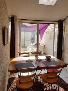 a dining room with a table and chairs and a window at Maison Arles in Arles