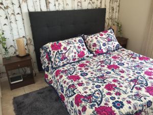 1 dormitorio con 1 cama con edredón de flores en El Faro Premium Frente al Mar, en La Serena