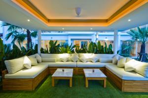 a living room with white couches and plants at Chi Samui Resort in Bophut