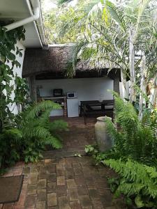 un patio con plantas y una cocina en una casa en Lighthouse Accommodation, en East London