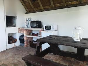 a kitchen with a wooden table and a microwave at Lighthouse Accommodation in East London +10 photos