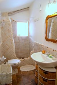 a bathroom with a sink and a toilet and a mirror at Appartamenti Storici al Mare in Bosa