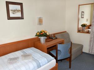 a hotel room with a bed and a desk and a chair at Hotellerie Waldesruh in Oberlimberg