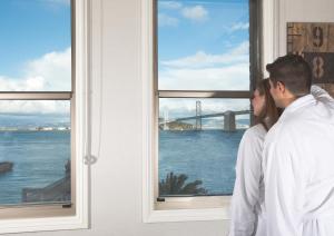 Ein Paar schaut aus dem Fenster auf die Brücke. in der Unterkunft Harbor Court Hotel in San Francisco