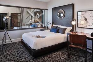 a bedroom with a bed and a desk and a mirror at Harbor Court Hotel in San Francisco