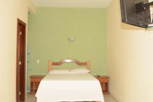 a bedroom with a bed and a television in it at Pousada Cavalo Marinho Anexo in Abraão