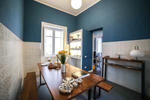 a dining room with blue walls and a wooden table at Family Affair Palermo in Palermo