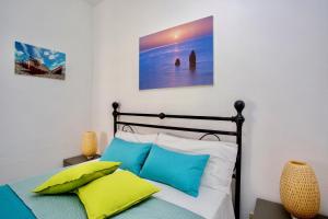 a bedroom with a bed with blue and white pillows at Il Veliero Blu Lipari Centro - Guest House in Lipari