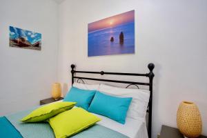 1 dormitorio con 1 cama con almohadas azules y blancas en Il Veliero Blu B&B Lipari Centro, en Lipari