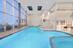 a large swimming pool in a building with windows at Wyndham Garden Midland in Midland