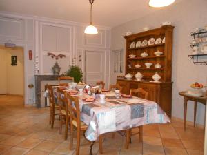 uma sala de jantar com uma mesa e cadeiras num quarto em AMBIANCES chambres d 'hôtes em Baye